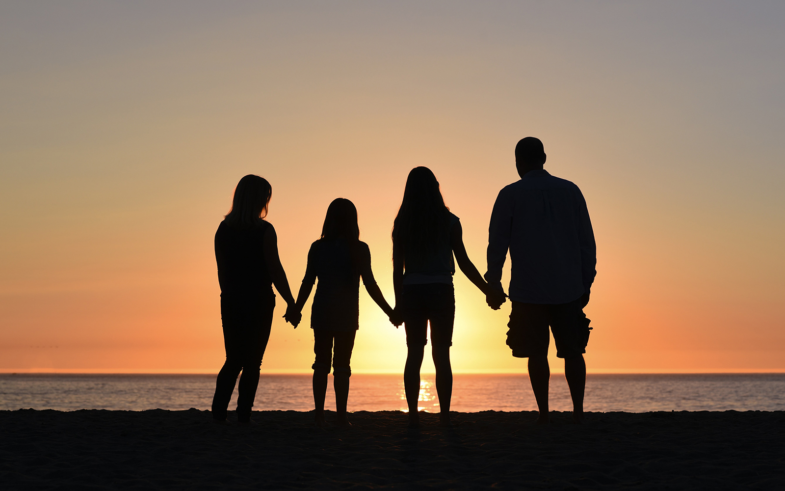 family on beach at sunset